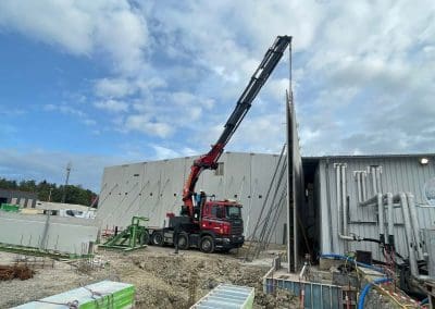 Levage et pose de pré-murs sur chantier avec camion grue